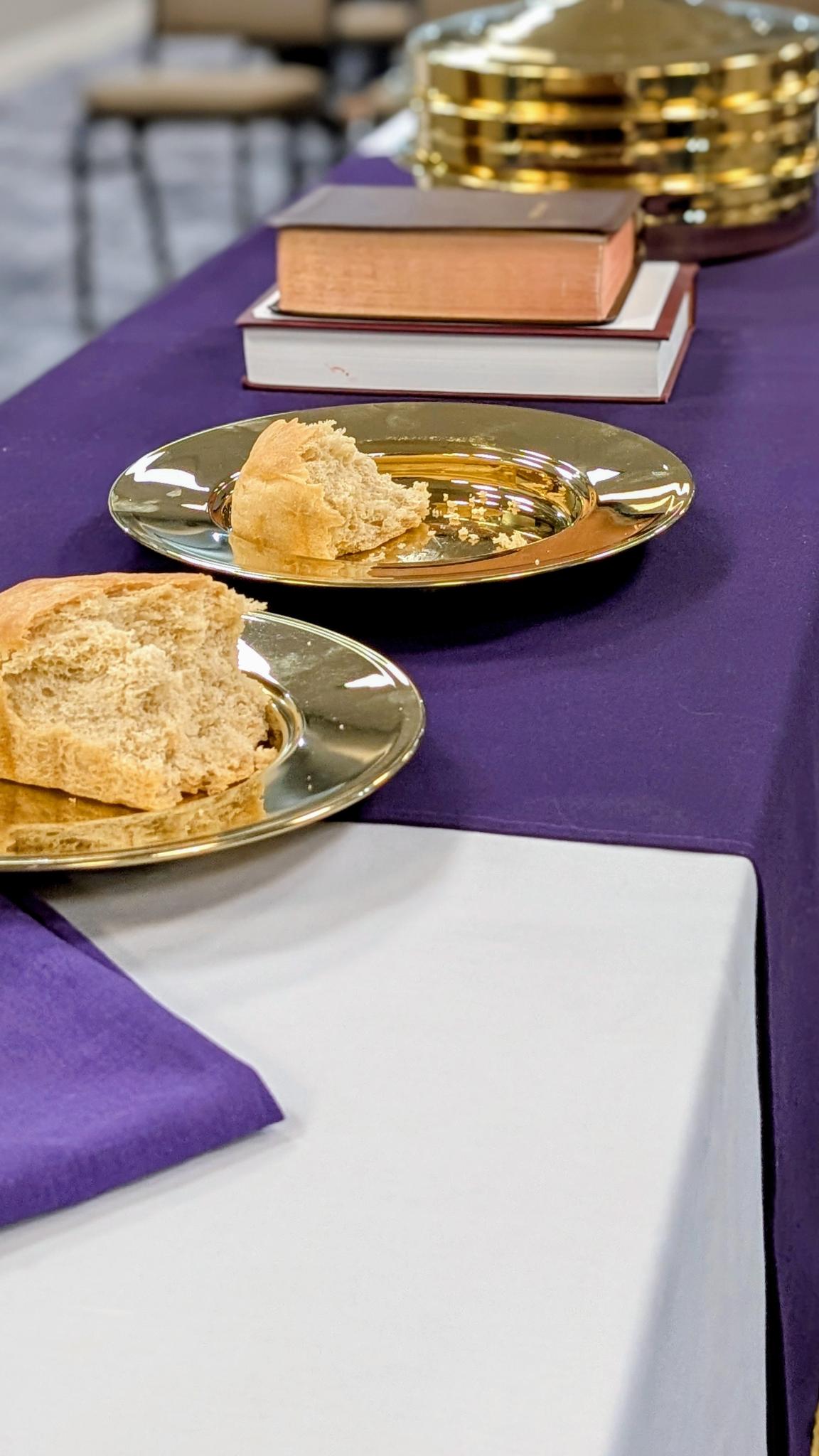 Bread broken on communion plates at the Lord's Table